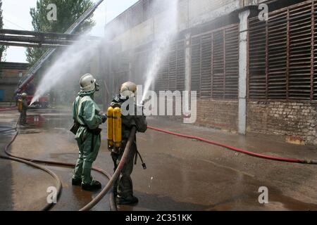 Feuerwehr in chemische Schutzanzüge und Gasmasken Stockfoto