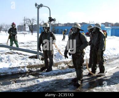 Feuerwehrleute in chemischen Schutzanzügen Stockfoto