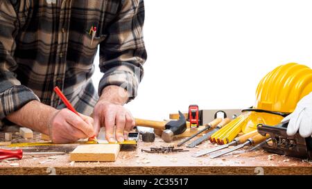 Nahaufnahme. Tischler mit Bleistift und Tischlerplatz zeichnen die Schnittlinie auf einem Holzbrett. Bauindustrie. Isoliert auf weißem Hintergrund. Stockfoto