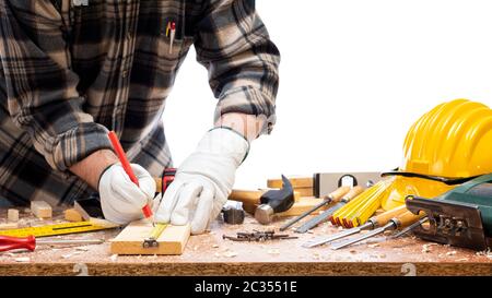 Nahaufnahme. Tischler mit den Händen durch Handschuhe mit Bleistift geschützt und das Messgerät markiert die Messung auf einem Holzbrett. Bauindustrie. Iso Stockfoto