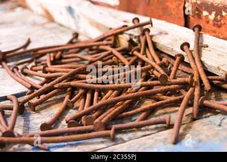 Verrostete Nägel auf einem Holzboden Stockfoto