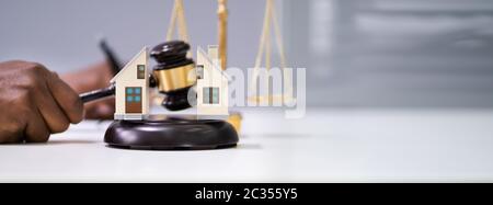 Nahaufnahme EINES Richters, der Gavel zwischen Split House über Desk schlägt Stockfoto