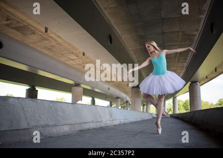 Anmutige Ballerina Tanz-Übungen auf eine Betonbrücke Stockfoto