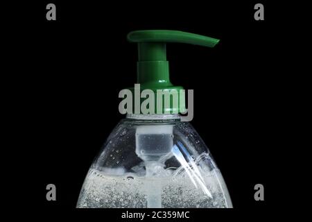 Hand-Waschen zur Vermeidung von Coronavirus (COVID-19) Konzept, steigende Seifenblasen in der Plastikflasche der Pumpe auf dem schwarzen Hintergrund. Nahaufnahme/Makroaufnahme Stockfoto