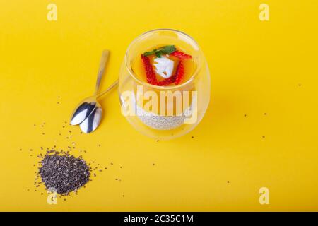 Mango-Pudding mit chia-Samen in Glas auf gelbem Hintergrund Stockfoto