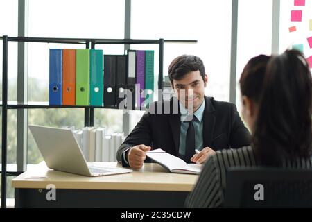 Junge Arbeitgeber in schwarzen Anzügen bewerten Stellenbewerber, indem sie Fragen zur Marketingstrategie stellen. Der Kandidat verstand nicht, was der Arbeitgeber war Stockfoto