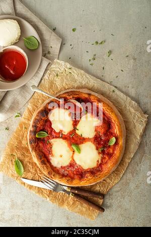 Pizza Margherita serviert mit Mozzarella, Tomaten und frischem Basilikum Stockfoto