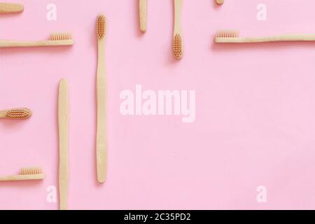 Draufsicht des zusammengesetzten Layouts mit organischen, abfallfreien Bambuszahnbürsten auf pinkfarbenem Hintergrund mit Kopierraum Stockfoto