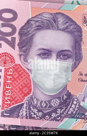 200 Griwna Banknote mit Lesya Ukrainka in einer medizinischen Maske, vertikal. Die Ukraine ist von einer Wirtschaftskrise betroffen. Ukrainisches Geld, Coronavirus Konzept, mont Stockfoto