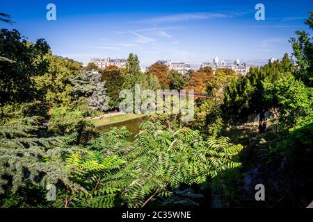 Teich und Brücke in Buttes-Chaumont Park im Sommer, Paris Stockfoto