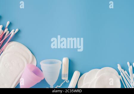 Feminines Hygienezubehör. Konzept der weiblichen Hygiene während der Menstruation. Sanitärpolster, Menstruationsbecher und Tampons, Wattestäbchen und Baumwollpolster Stockfoto