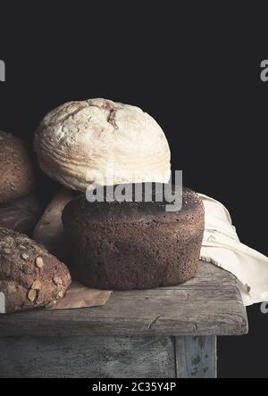 Verschiedene Brötchen Roggenbrot auf einer hölzernen Oberfläche, Vintage, Tonisierung, Nahaufnahme Stockfoto