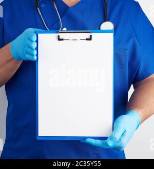 Arzt in der blauen Uniform und Latex Handschuhe hält die blaue Halterung für Blatt Papier, leeren Raum für das Schreiben von Text auf weißem Hintergrund Stockfoto