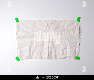 Zerknitterte schmutzigen weißen Stück Papier Handtuch mit dem Grünbuch Klettverschluss auf einem weißen Hintergrund geklebt, Platz für Text Stockfoto