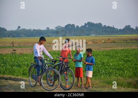 Einige indische Teenager Jungen genießen Radfahren in einem indischen Dorf am Abend, selektive Fokussierung Stockfoto