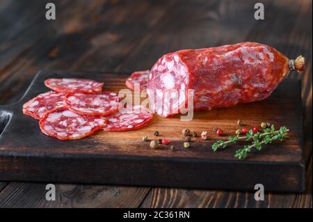 Italienische Salami mit frischem Thymian auf der Holzplatte Stockfoto