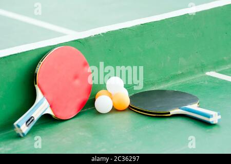 Tischtennis oder Pingpong Set, zwei Schläger und einige Bälle sind auf dem grünen Tisch. Stockfoto