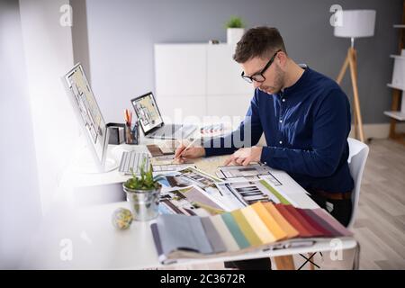 Seitenansicht von Immobilien Designer Arbeiten am Computer im Büro Stockfoto