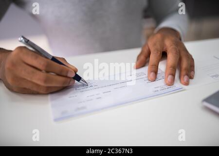 Nahaufnahme der Kaufmann Hand Unterzeichnung im Amt prüfen Stockfoto