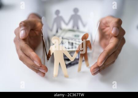 Die schützende Hand gestapelt Banknoten durch die menschlichen Figuren umgeben Stockfoto