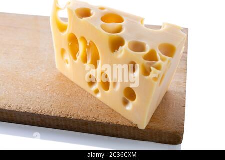 Schweizer Käse auf einem Holzbrett, isoliert. Stockfoto