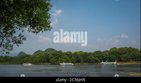 Guilin, China - August 2019: Kleine lokale Pkw Boote segeln auf den herrlichen Fluss Li von Guilin nach Yangshuo Stockfoto