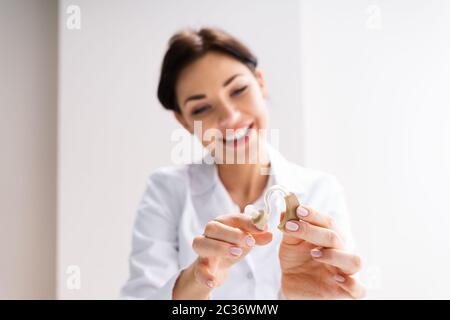 Weibliche Doktorin, Die Dem Patienten Hörgeräte Zeigt Stockfoto