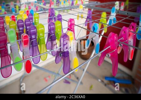 Viele bunte Wäscheklappen auf einem Trockengestell Stockfoto