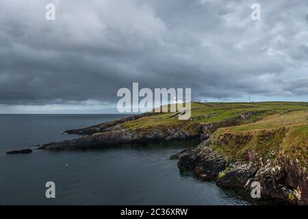 Galley Head, Cork, Irland. 19. Juni 2020.Frühe Morgenbeleuchtung beleuchtet den Galey Head Leuchtturm gegen den brütenden Himmel einer entgegenkommenden Wetterfront in Co. Cork, Irland. - Credit; David Creedon / Alamy Live News Stockfoto