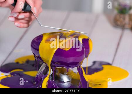 Schritt für Schritt wird der Mousse Kuchen mit Spiegelglasur gebacken. Französisches Dessert wird zubereitet. Gefrorenes Spiegel-Icing auf dem Kuchen. Backen und Konditorei Stockfoto