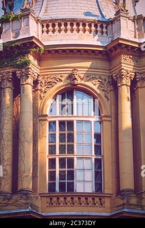 Bogenfenster mit einem schönen alten Stein Relief Zierdekoration, Porträt, florale Elemente und Säulen. Schloss Vajdahunyad in Budapest. Stockfoto