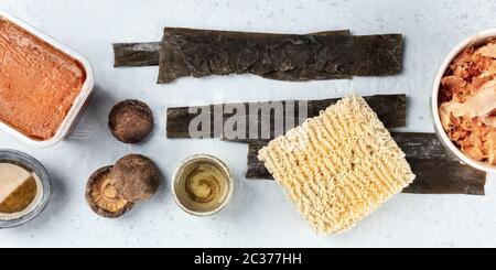 Ramen Zutaten Panorama. Getrockneter Seegrüsenkelch, Soba Instant Nudeln, rote Miso Paste, Thunfisch Flocken, Shiitake Pilze, sak Stockfoto