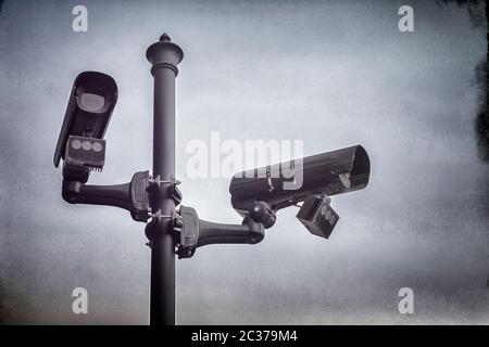 Zwei CCTV-Überwachungskameras, die an einem Mast in der Straße montiert sind. Stockfoto