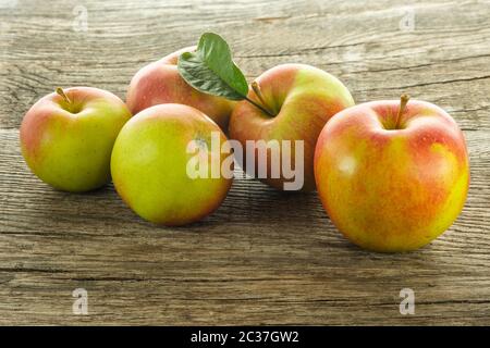 Heap rot grün wellnat Äpfel auf rustikalem Holz Stockfoto
