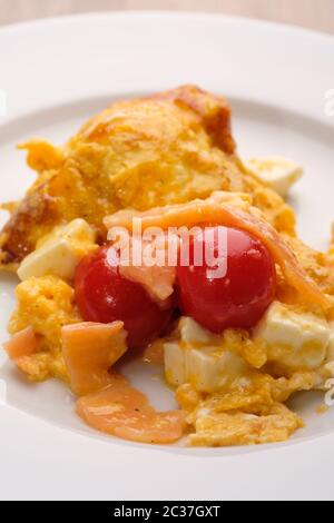 Rote Tomaten mit geräuchertem Lachs, Käse und geschrottenen Eiern im Hochformat Stockfoto