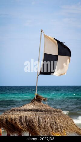 Flaggen am Strand weisen auf Gefahren wie Quallen, Unterstrom und andere Gefahren hin Stockfoto