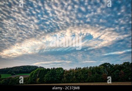 Eine besondere Lochwolke in einem blauen Himmel Stockfoto