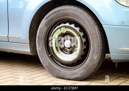Ein Notrad war nach einer Reifenpanne an einem Auto montiert Stockfoto