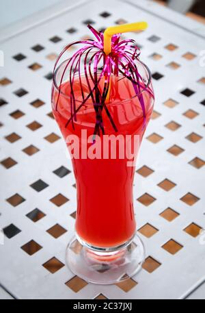 Ein Glas mit einem Cocktail auf einem Poolhocker Stockfoto