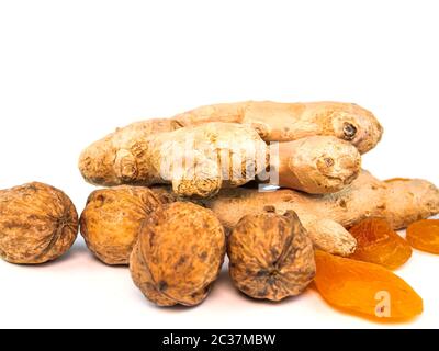 Ingwer Wurzel mit Walnüssen und getrocknete Aprikosen Aprikosen auf einem weißen Hintergrund. Essen Foto. Für Text platzieren. Ethnoscience. Stockfoto