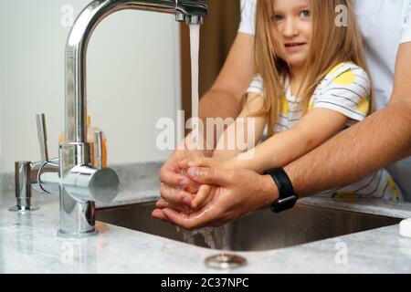 Vater und Tochter waschen sich die Hände über dem Waschbecken in einer Küche Stockfoto