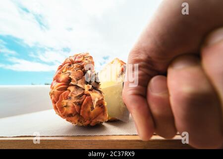 Mann schneiden Ananas - Nahaufnahme männliche Hand halten scharfe Messer Vorbereitung tropische Früchte Smoothies - Menschen Lebensstil und gesunde exotische Lebensmittel Konzept Stockfoto