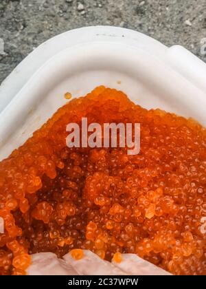 Roter Kaviar in einem Plastikbehälter. Lachskaviar, Diätkost. Stockfoto