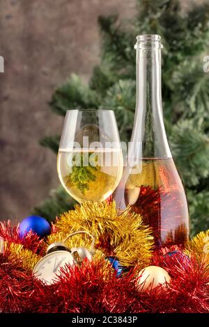 Weihnachten-Stillleben mit Champagner und Dekorationen am Weihnachtsbaum vor verschwommenen Hintergrund Stockfoto