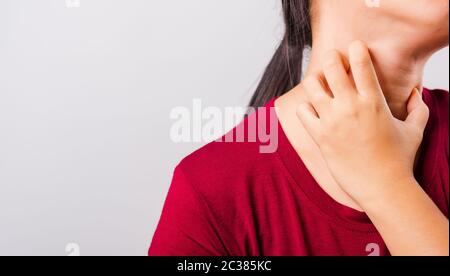 Die schöne asiatische Frau, die ihr den juckenden Hals auf weißem Hintergrund mit Copy-Space, Medical and Healthcare Concept kratzt Stockfoto