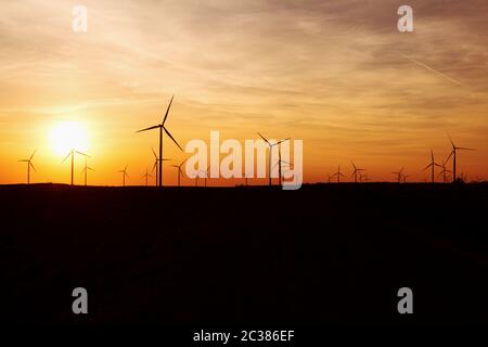 Windenergieanlagen über Sonnenuntergang Himmel Stromerzeugung. Nachhaltige Energie Stromerzeuger, Erneuerbare Stromversorgung Stockfoto