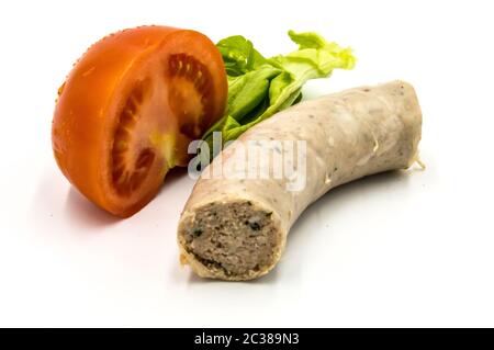 Stück Weißwurst auf weißem Grund mit einer halben Tomate und einem Salatblatt Stockfoto