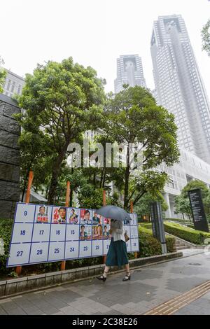 Fußgänger kommen an einem Plakatbrett vorbei, das mit Plakaten für die bevorstehenden Gouverneurswahlen in Tokio nahe dem Gebäude der Tokyo Metropolitan Government am 19. Juni 2020 in Tokio, Japan, aufgestellt wurde. Die Kampagne begann offiziell am Donnerstag, 18. Juni, und wird am 5. Juli stattfinden. Quelle: Rodrigo Reyes Marin/AFLO/Alamy Live News Stockfoto