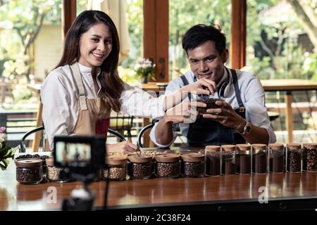 VLOG von jungen erwachsenen Asiatischen Eigentümer Unternehmer bewerten cafe Coffee Shop und Leben in sozialen Medien für Online Marketing mit Kamera im Cafe. Verwendung für Sta Stockfoto