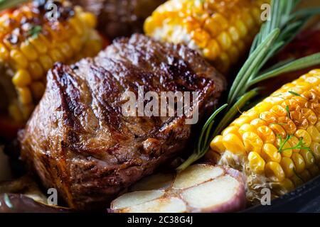 Stück gebratenes Fleisch, umgeben von Mais. Edoard Hintergrund. Das Konzept der natürlichen Nahrung. Stockfoto